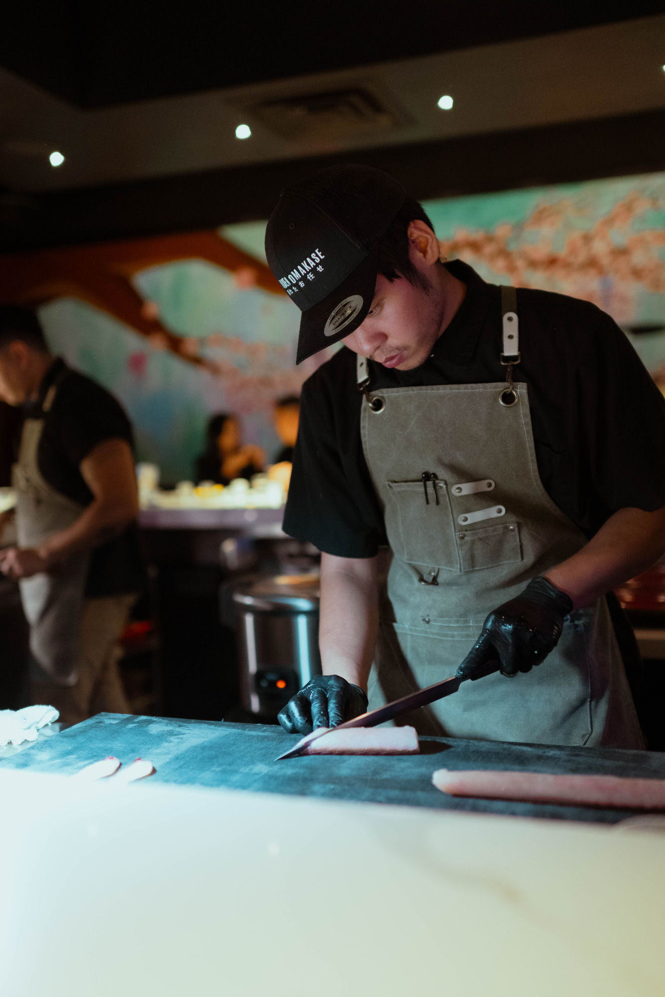 Chef Kaelyb Lim slicing fish at the omakase counter